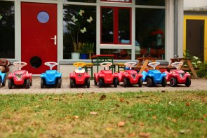 Mehrere Bobbycars vor einer Kita