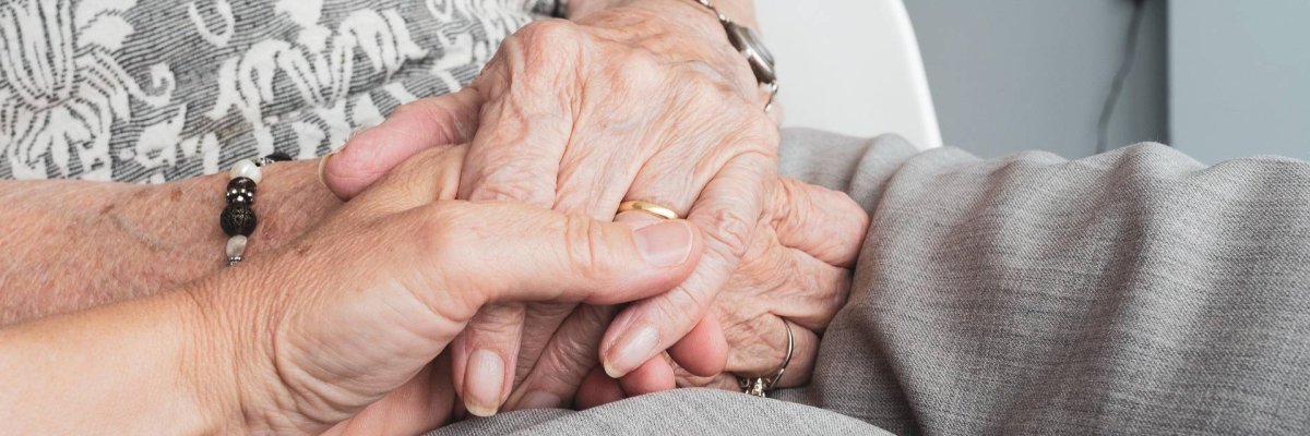 Jüngere Hand hält alte Hände