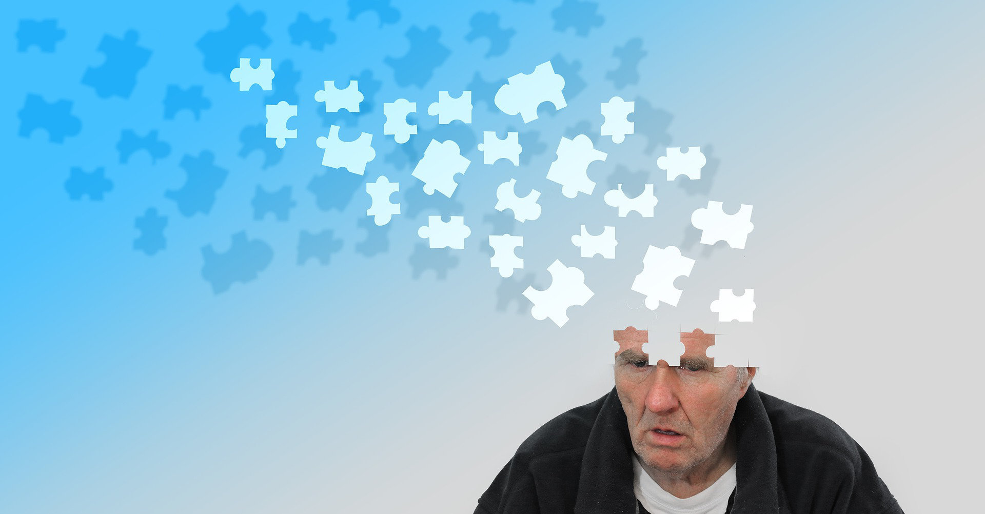 Alter Mann mit Demenz, dessen Kopf sich in Puzzleteilen auflöst.