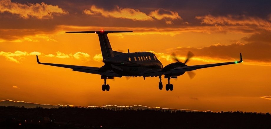 Turbo-Prop Flugzeug beim Start vor einem Nachthimmel