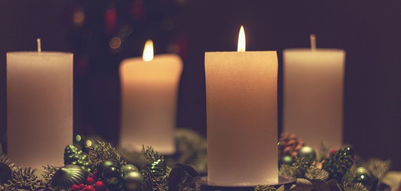Adventsgesteck mit zwei brennenden Kerzen